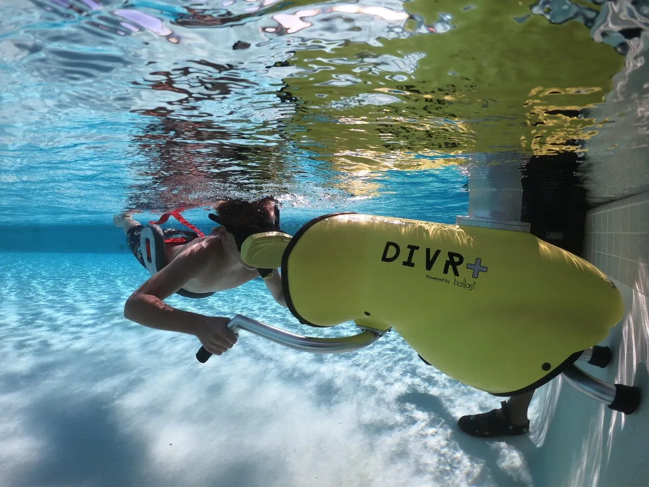Guest floating face-down in a pool wearing a Ballast VR headset