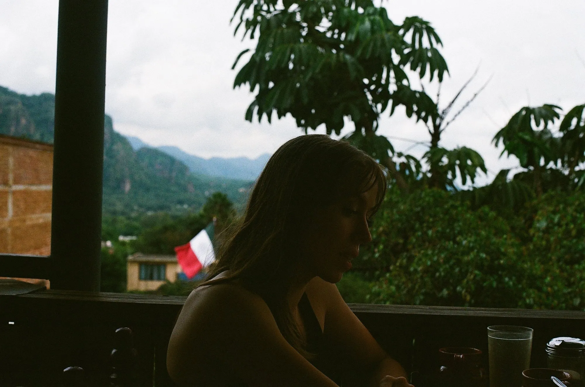 Emily O'Neal at a balcony table, mountains behind her